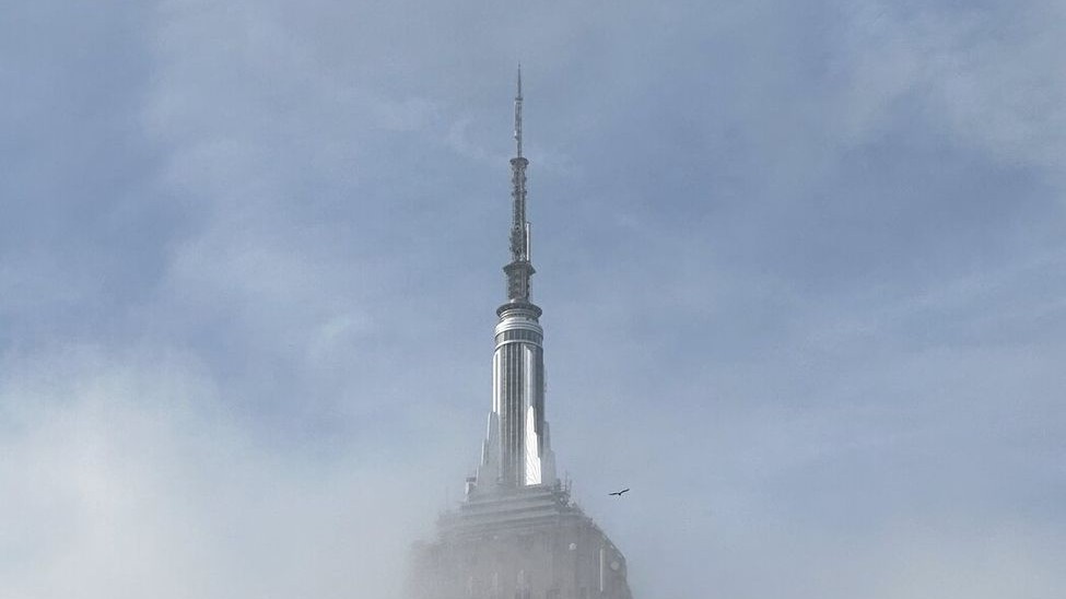 The Empire State spire emerging above a bank of fog