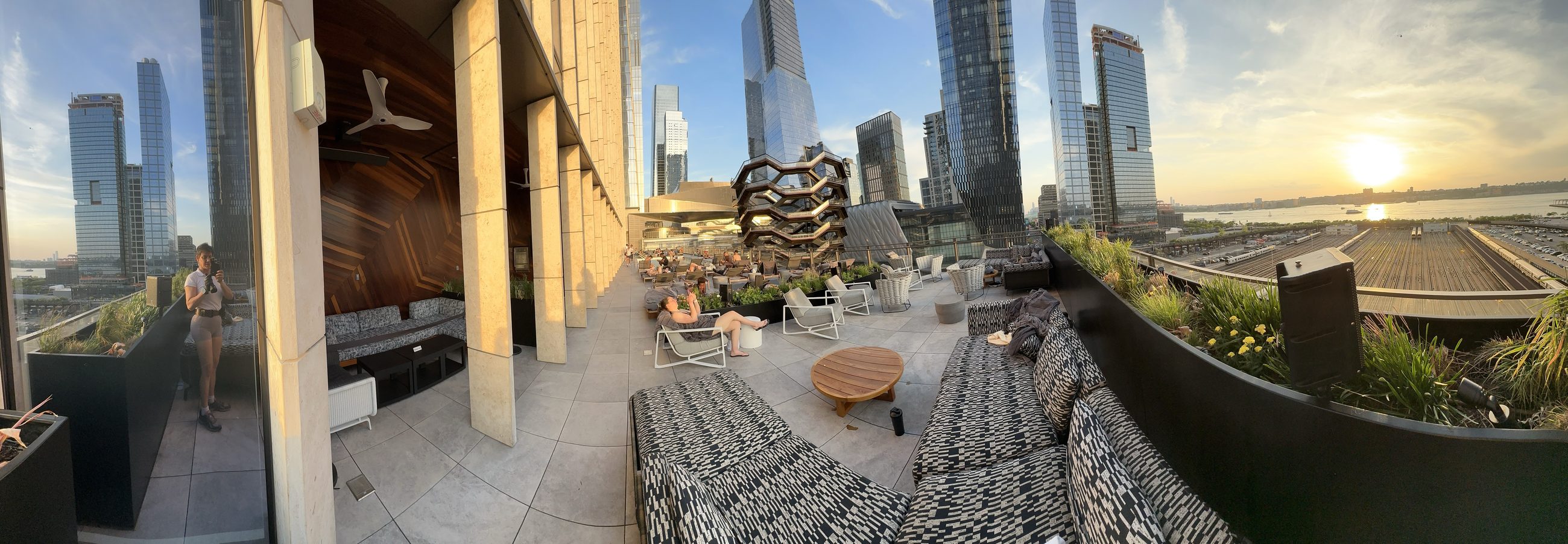 A rooftop terrace as the sun goes down over the Hudson